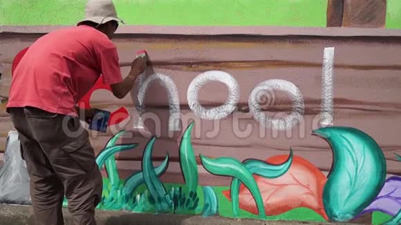 壁画画家在混凝土墙上画一个字母h时间间隔视频的预览图