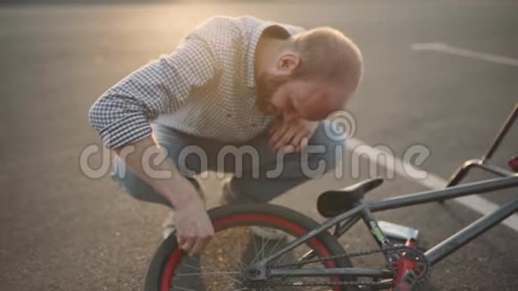 一个年轻人把他的bmx自行车从泥土中清洗日落慢速运动视频的预览图