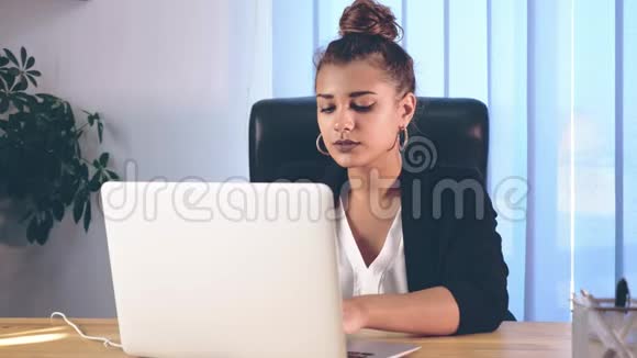女孩穿着时髦的衣服坐在办公室里打印一部纪录片视频的预览图
