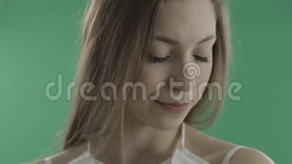 绿色背景下谦逊的年轻女人视频的预览图