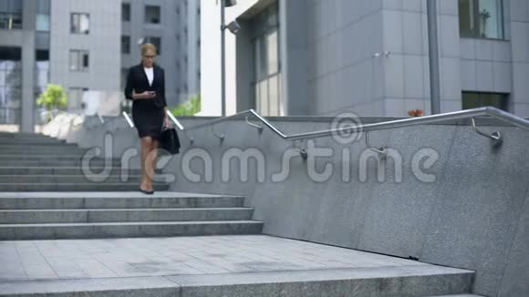 优雅的女士走下楼梯在智能手机上查看邮件忙碌的生活方式视频的预览图