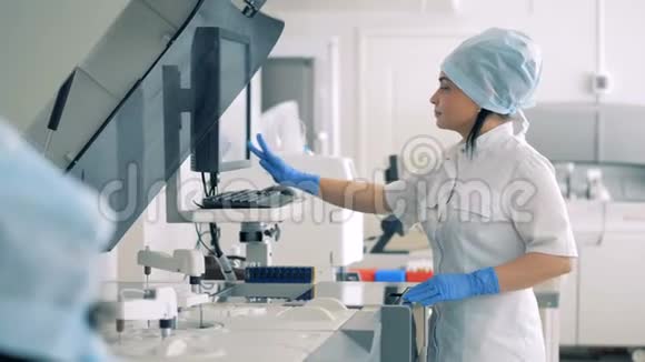 女实验室专家正在管理自动制药设备视频的预览图