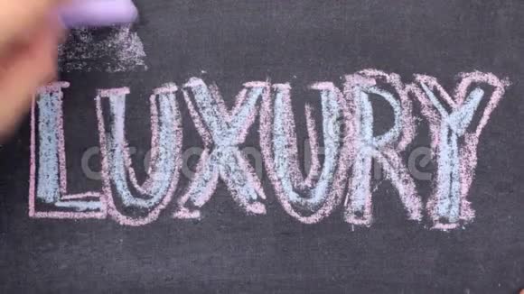 单词LUXURY用粉笔在黑板上手写视频的预览图