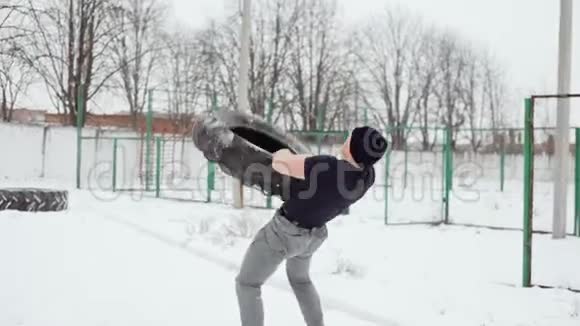 一个人在冬天做交叉健身运动他把橡胶轮胎扔在自己身上视频的预览图