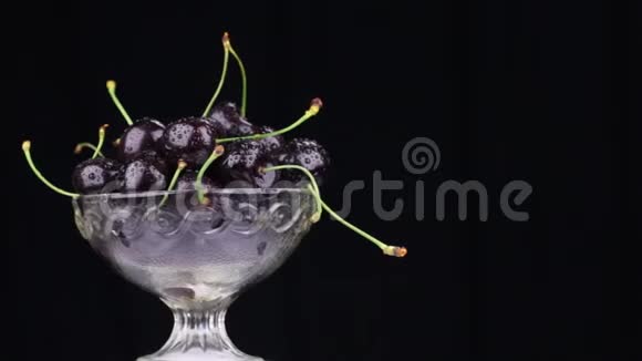 玻璃花瓶里一堆黑樱桃的旋转视频的预览图