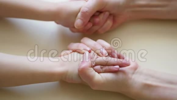 妈妈的手触摸孩子她的手特写妈妈的手孩子的手慢慢地握住孩子的手视频的预览图