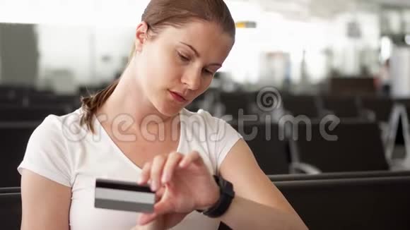 在机场等待航班起飞时女士在网上用信用卡购物视频的预览图