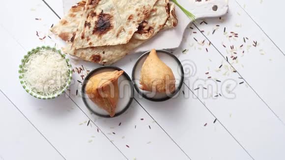 在白色木桌上放在盘子里的传统印度食品小吃Samosa视频的预览图