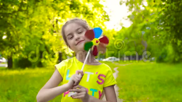 小女孩拿着五颜六色的风车视频的预览图
