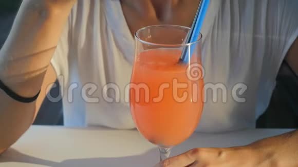 女人喝着清爽的橙色鸡尾酒视频的预览图
