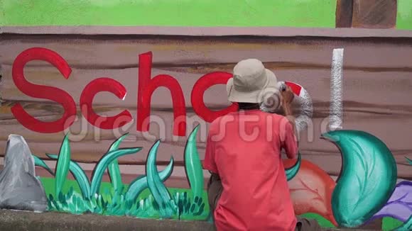 壁画画家在混凝土墙上画一个字母o时间间隔视频的预览图
