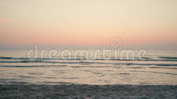 日落时分女人在海滩上沿着海岸快速奔跑慢动作视频的预览图