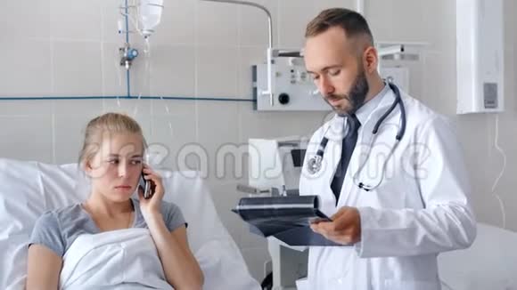 男医生在医院病房探视女病人病人在打电话视频的预览图