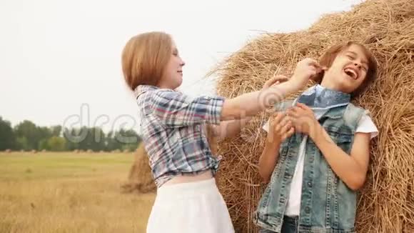 可爱的快乐男孩和女孩在田里玩干草视频的预览图