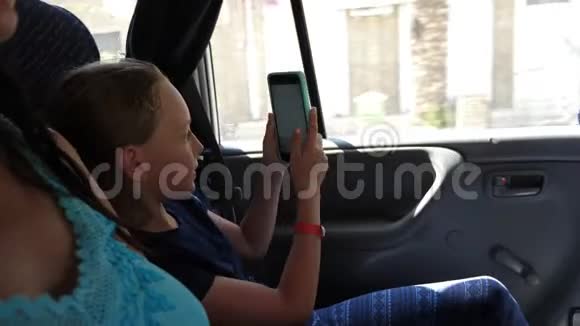 少女在开车旅行时用手机拍摄视频视频的预览图