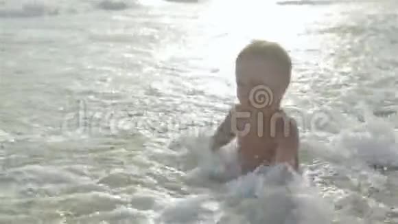 小活泼快乐的男孩儿子在海里游泳他跑跳溅掉进水里视频的预览图