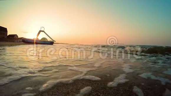 海上日出双体船站在海边的海滩上一个夏天的早晨沙滩被海浪冲走了视频的预览图