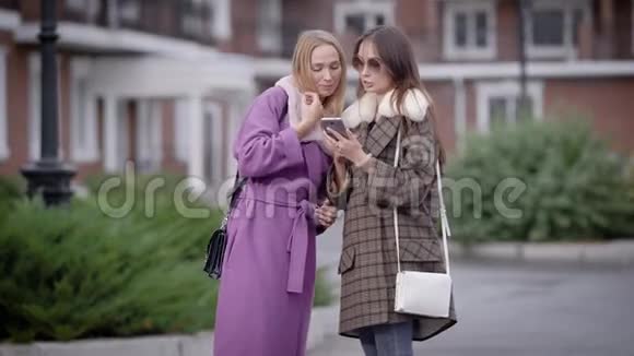 两个穿外套的漂亮女孩秋天是走在城市街道上的大好时光视频的预览图