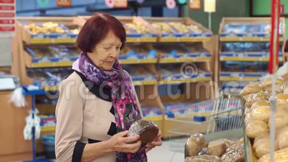 八十岁的祖母在杂货店挑选和买面包视频的预览图