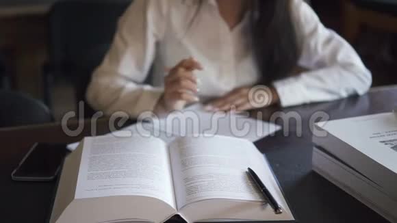 书躺在桌子上女学生穿着白色衬衫在做领事视频的预览图