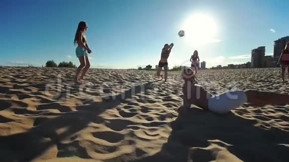 一群年轻的运动员打沙滩排球其中一名运动员在秋天从沙滩上站起来视频的预览图