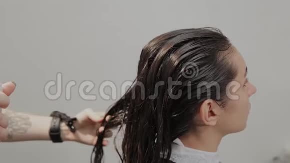 女理发师给客户梳湿头发视频的预览图