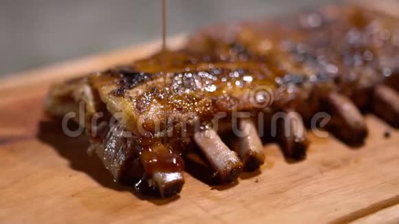 刚煮好的多汁香炒排骨浇上烧烤酱在木桌上摆放精美关门视频的预览图