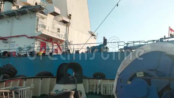 在海上拖船海上拖船靠近货船拖船在船甲板上戴头盔的人视频的预览图