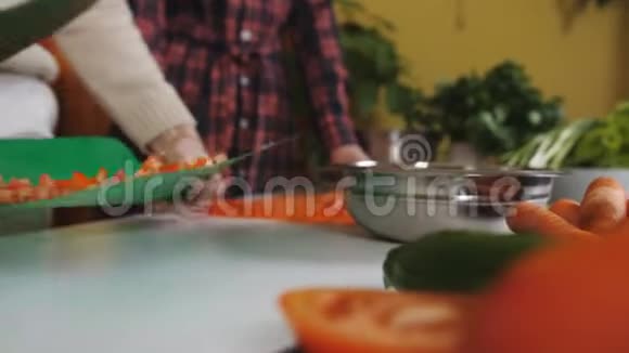 两个女孩在厨房里做沙拉健康食品和切番茄视频的预览图