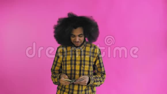 年轻的非裔美国人在紫色背景上数现金钱视频的预览图