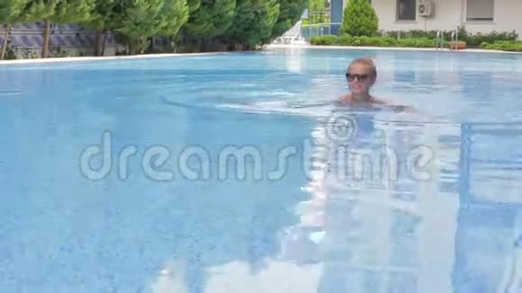 女孩在游泳池里游泳视频的预览图