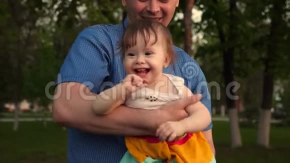 宝贝嘲笑爱父亲的手宝贝和爸爸笑着一起在公园散步视频的预览图