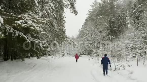 在冬季森林休闲滑雪时一个活跃的男人跟着妻子搬家视频的预览图