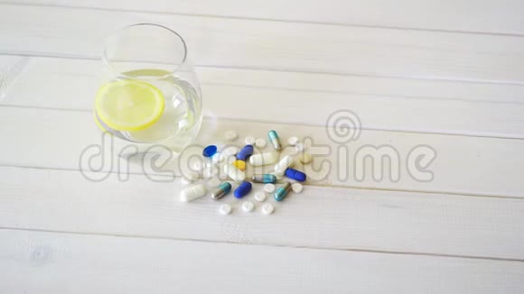 一杯柠檬水晶水和一套白色木桌上的药片视频的预览图