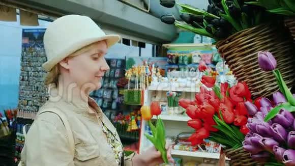 一个女人在阿姆斯特丹著名的花卉市场上选择郁金香视频的预览图