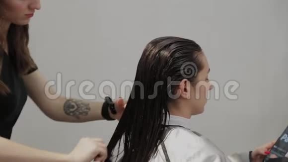 女理发师给客户梳湿头发视频的预览图