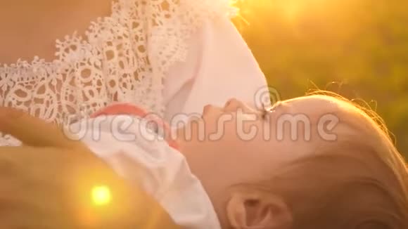 一个小婴儿睡在母亲的怀里日落时分慢镜头拍摄特写镜头视频的预览图