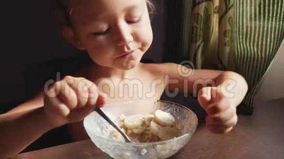 这孩子正在吃早餐小可爱女孩吃粥的肖像视频的预览图