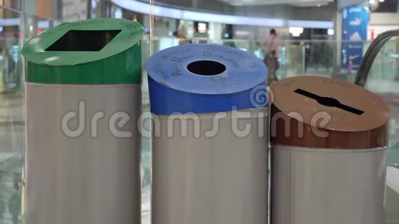 女人用纸塑料和玻璃标志把纸回收到垃圾桶里废物分类和回收视频的预览图