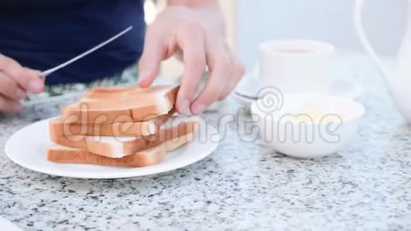 女人正在用黄油烤烤土司桌刀做早餐三明治视频的预览图