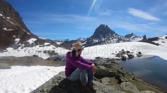 在法国比利牛斯山脉中徒步旅行的女人休息并看着皮蒂奥索视频的预览图