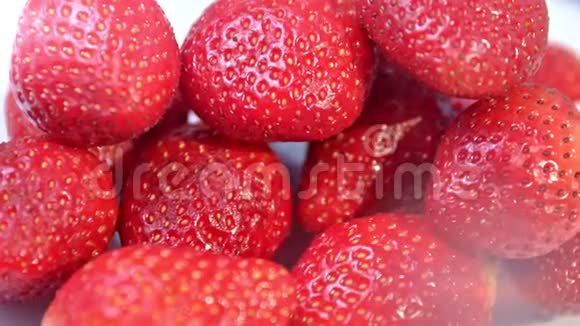 特写一堆光滑的新鲜成熟的红色草莓旋转镜头视频的预览图