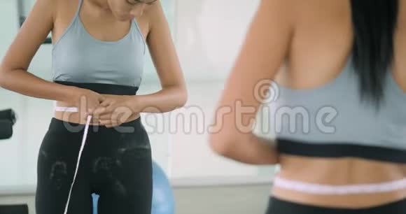 健身房里的女人在镜子前挣扎着视频的预览图