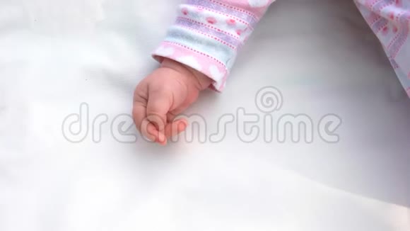 新生女孩的手在白色地毯上视频的预览图