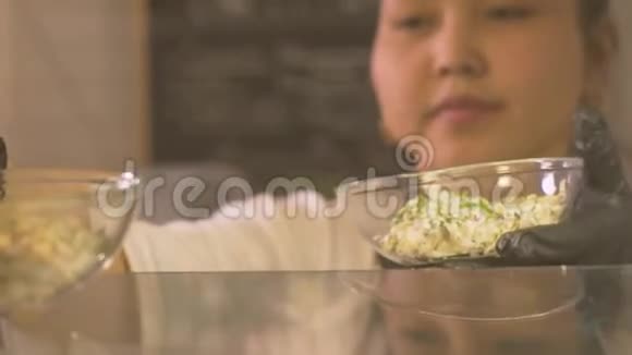 女人在商店橱窗里的餐馆里放一碗沙拉作为商务午餐视频的预览图