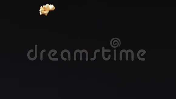 新鲜爆米花掉在黑色背景下的地上视频的预览图