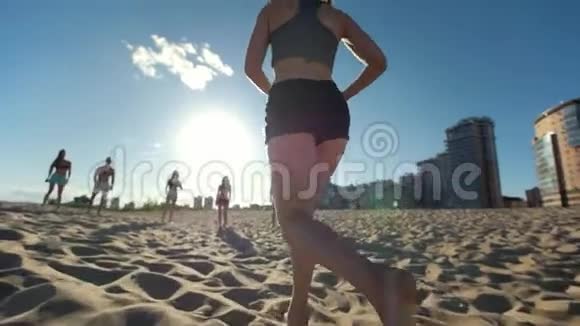 年轻苗条的女孩边打沙滩排球边跑边把球传给朋友视频的预览图