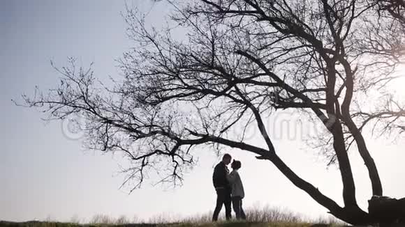 一对浪漫的约会情侣在大自然的一棵大树旁视频的预览图