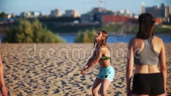 在沙滩排球比赛中留着长发的美丽苗条的女孩打球视频的预览图