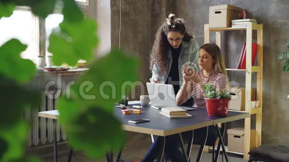 小企业的年轻业主正在现代阁楼风格的办公室里使用笔记本电脑金发女郎坐着打字视频的预览图